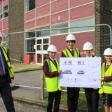 Nigel Pressnell, headteacher of The Arnewood School, with pupils holding the new plans