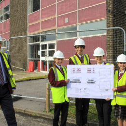 Nigel Pressnell, headteacher of The Arnewood School, with pupils holding the new plans